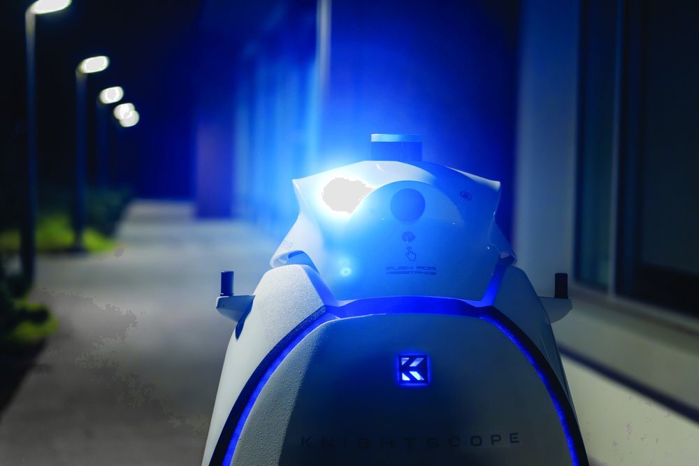 Knightscope K5 Autonomous Security Robot patrolling a lit walkway at night